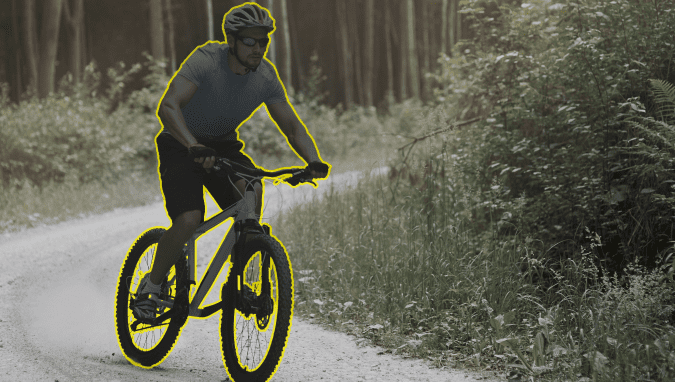 Annotation services are employed to highlight a young man riding a bicycle in the forest using Polygon Annotation.
