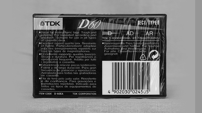 A greyscale image of a TDK D60 cassette with a barcode.